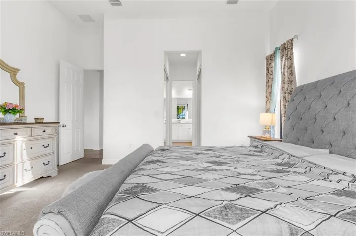 Bedroom with connected bathroom and light carpet