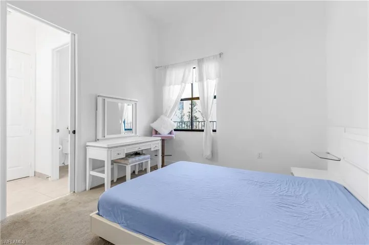 Bedroom featuring light carpet