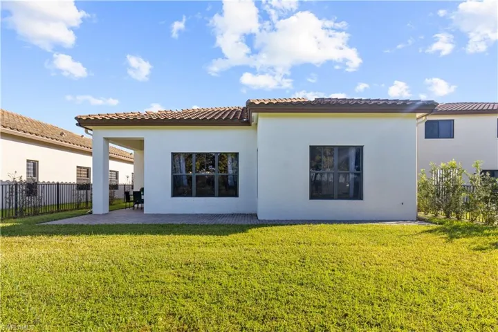 Rear view of house featuring a patio and a lawn