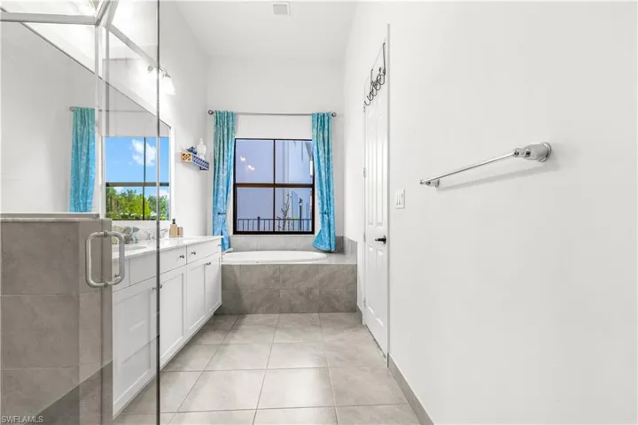 Bathroom featuring vanity, separate shower and tub, and tile patterned flooring