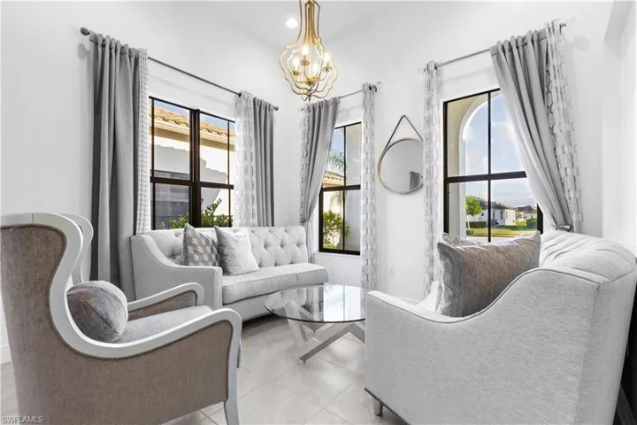 Sitting room with light tile patterned floors and a chandelier