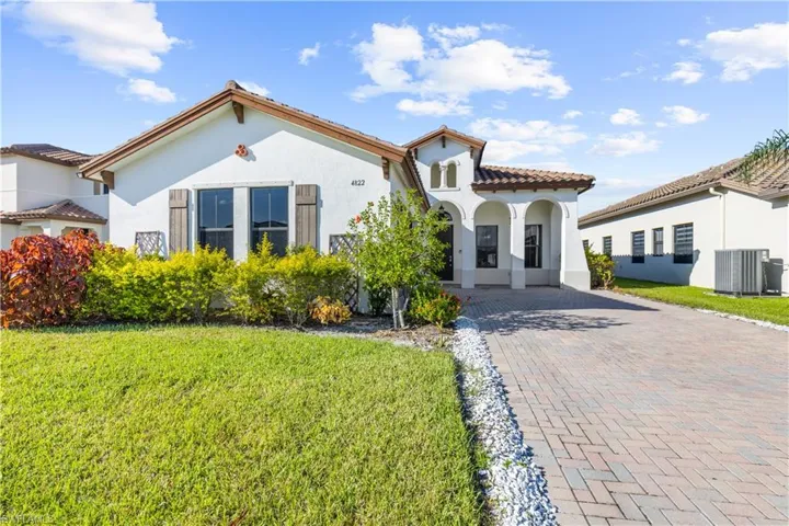 Mediterranean / spanish-style home with a front lawn and central AC