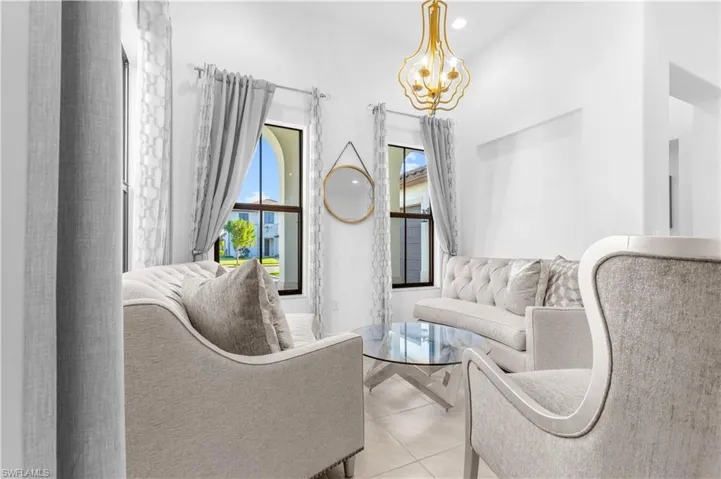 Living room featuring light tile patterned flooring and a chandelier