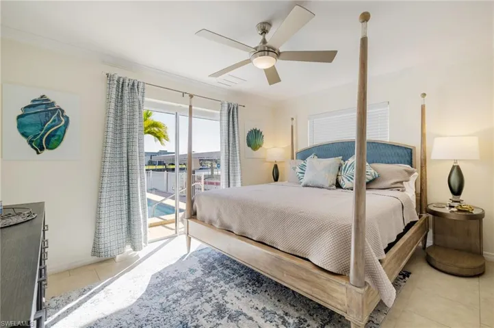 Bedroom featuring access to outside, light tile patterned flooring, a ceiling fan, and ornamental molding
