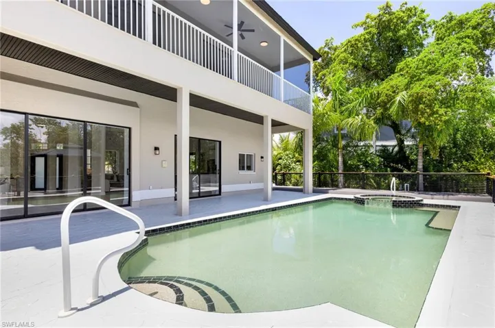 View of pool with a patio area and an in ground hot tub