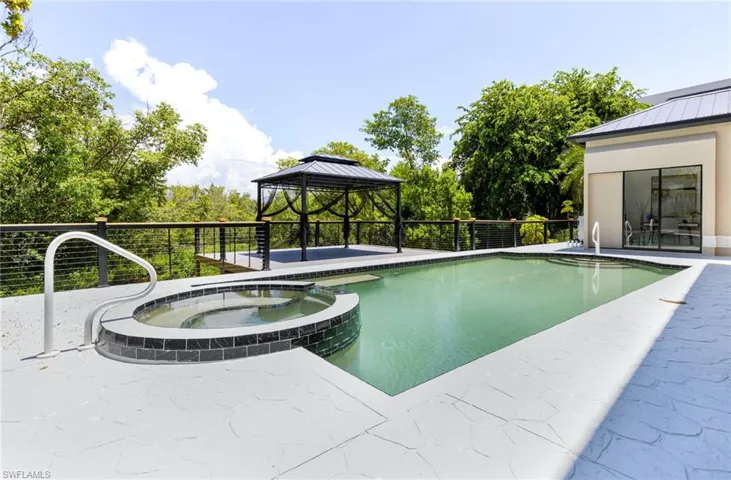View of swimming pool featuring an in ground hot tub, a patio, and a gazebo