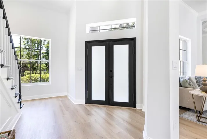 Entrance foyer with a high ceiling, french doors, and light hardwood / wood-style flooring