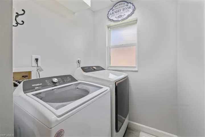 Laundry room with washing machine and clothes dryer and baseboards