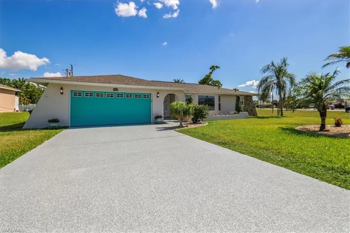 Single story home with a garage, stucco siding, concrete driveway, and a front yard