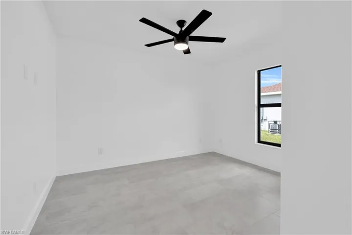 Empty room featuring baseboards and a ceiling fan