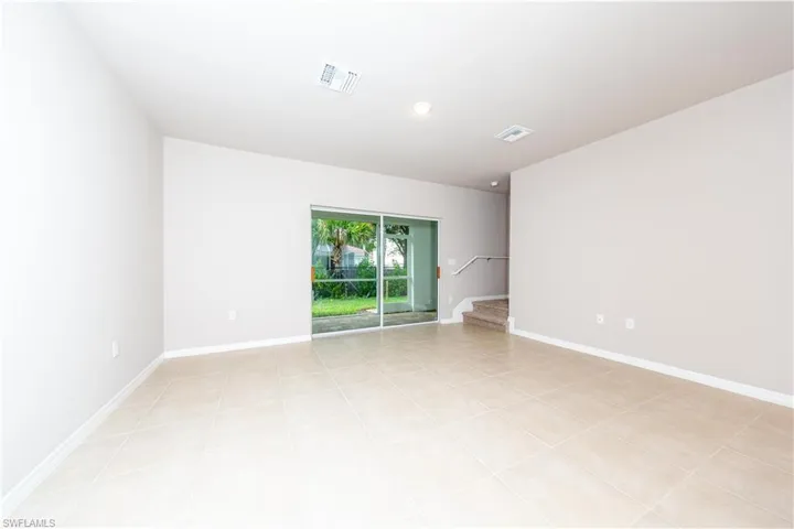 Unfurnished room with stairway, baseboards, and light tile patterned flooring