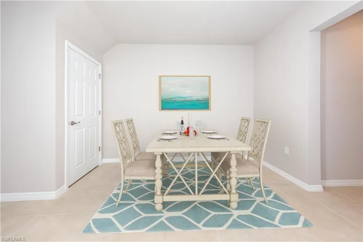 Dining area featuring light tile patterned floors and baseboards