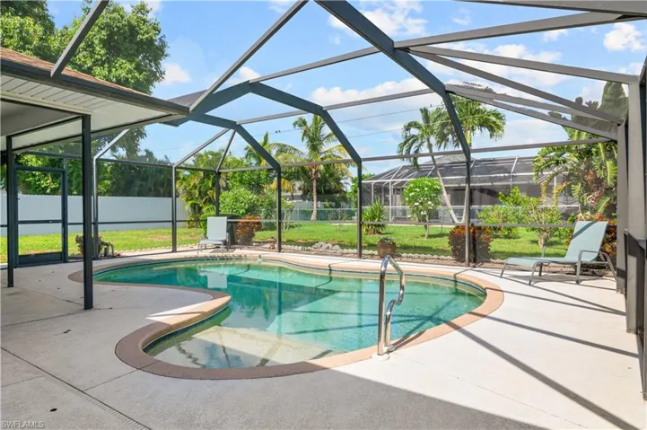 Outdoor pool featuring a patio area and glass enclosure