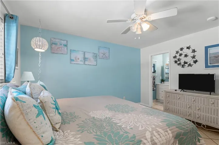 Tiled bedroom with ensuite bathroom and a ceiling fan