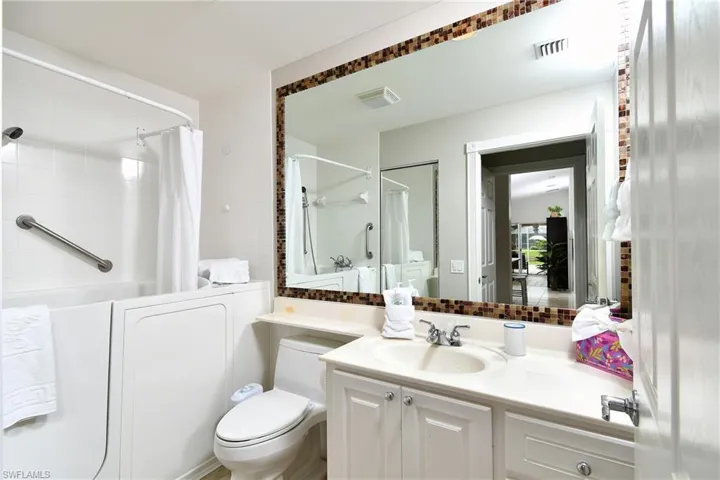 Large vanity with integrated sink, white cabinetry, and polished chrome fixtures