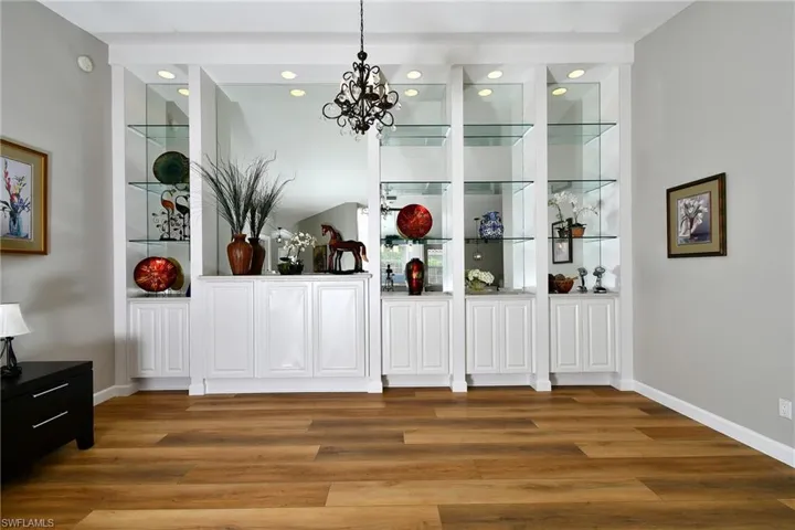 Built-in display cabinetry with glass shelving, recessed lighting, and lower storage