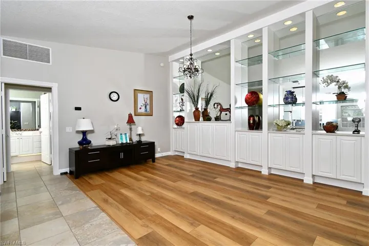 Built-in cabinetry with glass shelving and integrated lighting
