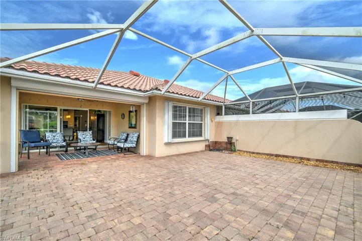 Screened lanai with brick paver flooring, offering an expansive outdoor living area