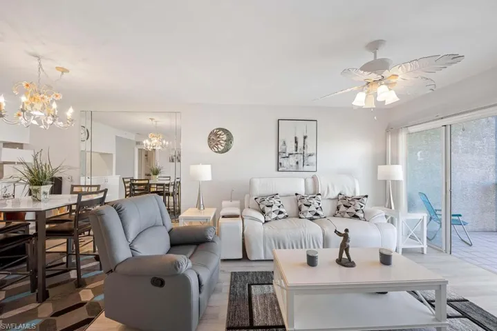 Living room with ceiling fan with notable chandelier
