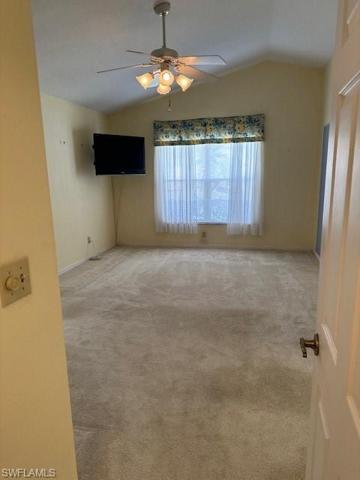 Primary bedroom with vaulted ceilings and access to sunroom.