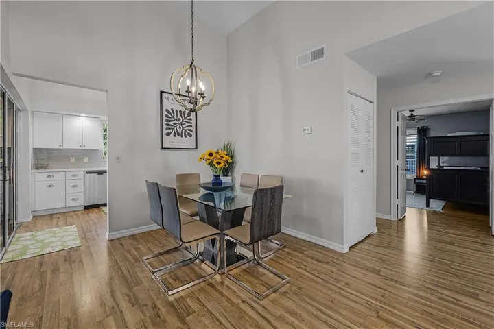 Dining area featuring a chandelier, light wood finished floors, and lofted ceiling