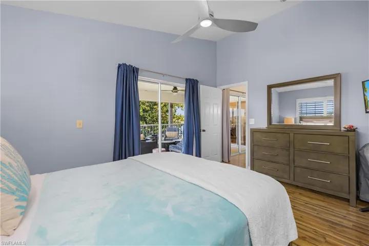 Bedroom with access to exterior, wood finished floors, a ceiling fan, and a closet