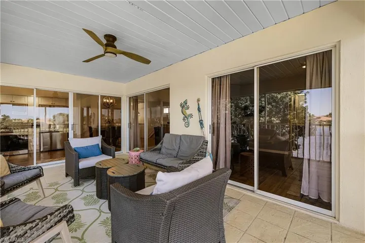 Sunroom featuring a ceiling fan, a patio, an outdoor hangout area, and healthy amount of natural light