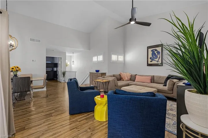 Living area featuring wood finished floors, vaulted ceiling, and a ceiling fan