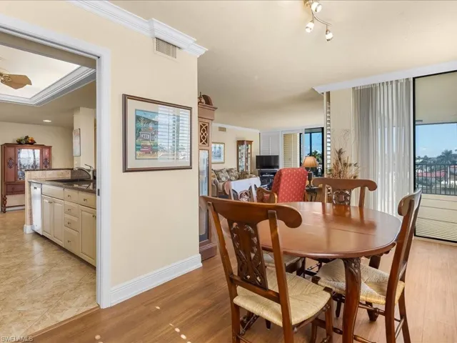 Dining area with light wood-style flooring, crown molding, and ceiling fan