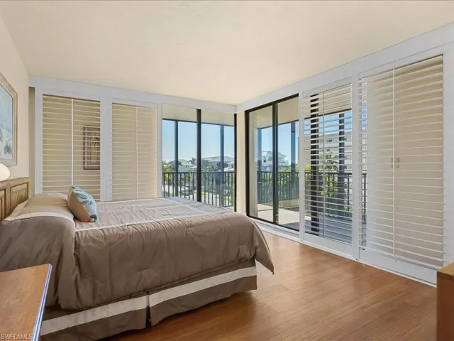 West Bedroom featuring slider access to screened wrap around balcony and ocean view