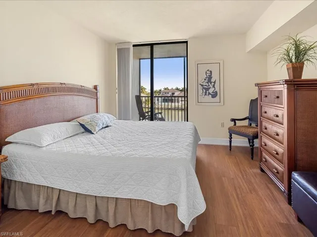 East Bedroom featuring access to slider access to screened balcony overlooking docks and bay