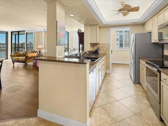 Kitchen featuring open floor plan, granite topped generous breakfast bar, stainless steel appliances, decorative backsplash, plenty of natural light, and ornamental molding