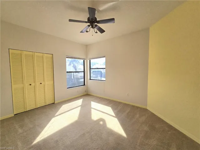 Unfurnished bedroom featuring carpet flooring, ceiling fan, and a closet