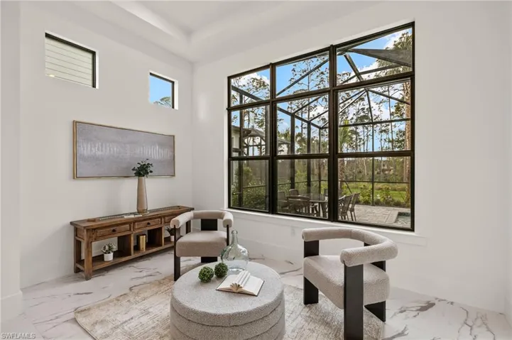 Living area with baseboards and marble finish floor