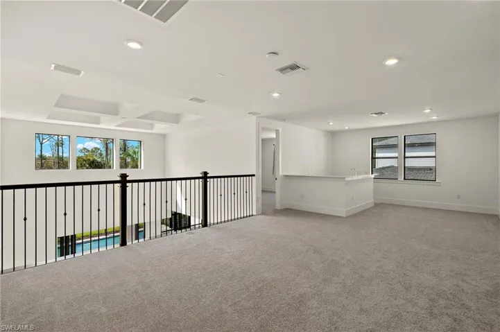 Unfurnished room featuring a wealth of natural light, visible vents, light carpet, and recessed lighting