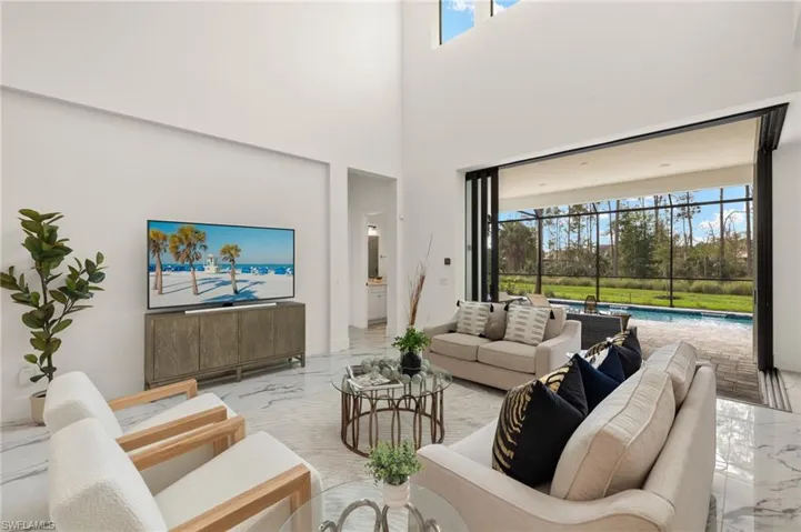 Living room with a towering ceiling and marble finish floor
