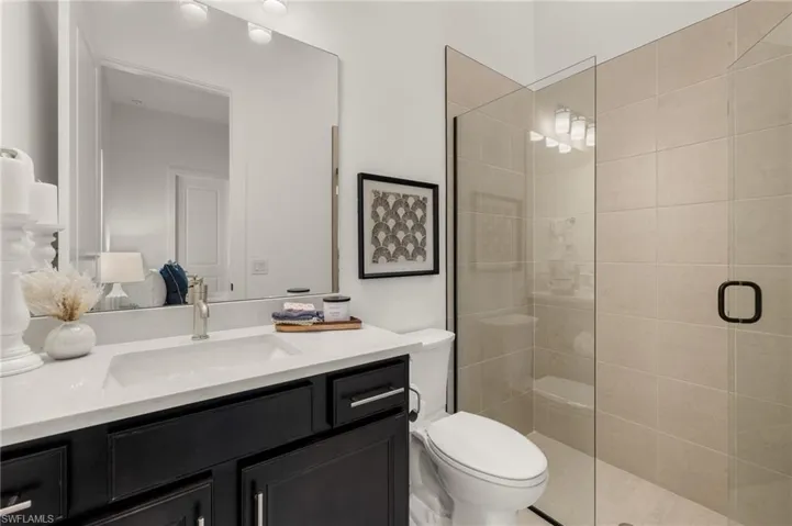 Bathroom with a stall shower, vanity, and toilet