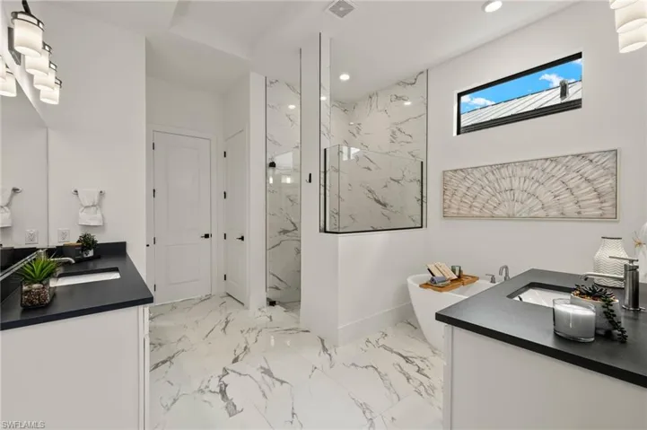 Full bathroom featuring a marble finish shower, two vanities, marble finish floor, a sink, and recessed lighting