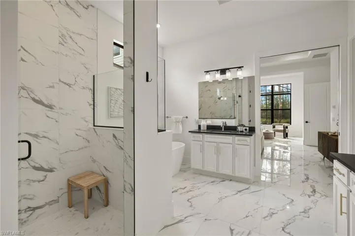 Bathroom with marble finish floor, vanity, visible vents, a freestanding tub, and a marble finish shower