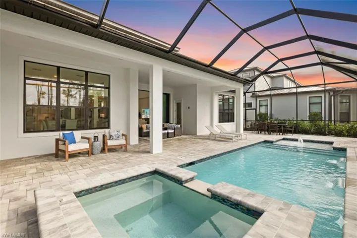View of pool featuring a pool with connected hot tub, a sunroom, a patio area, a lanai, and outdoor lounge area