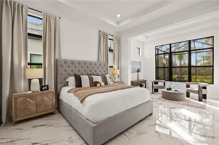 Bedroom featuring recessed lighting, a raised ceiling, and marble finish floor