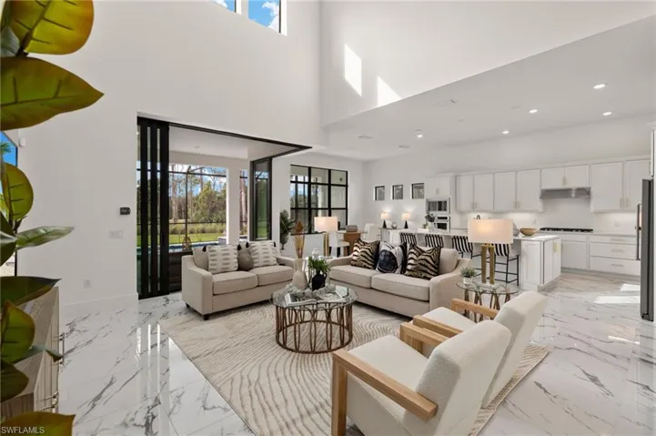 Living room featuring plenty of natural light, recessed lighting, marble finish floor, and baseboards