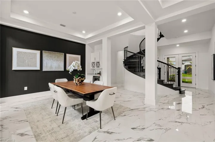Dining room featuring french doors, recessed lighting, marble finish floor, stairway, and a tray ceiling