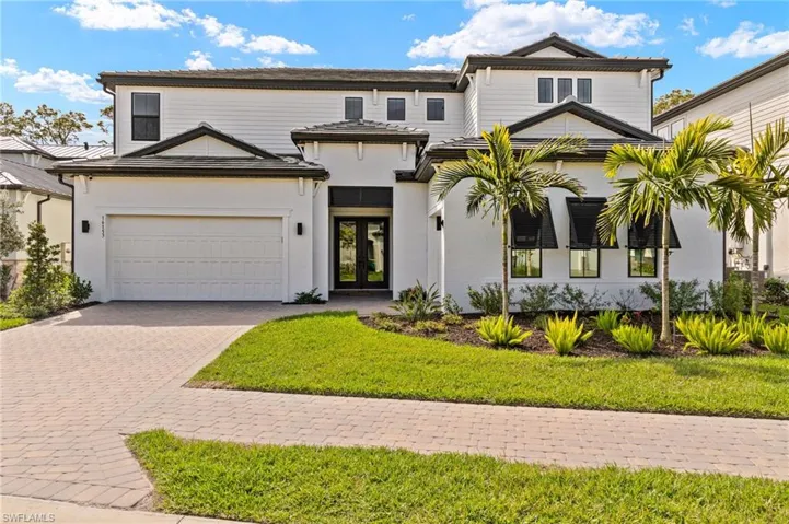 View of front of home featuring decorative driveway and a front yard