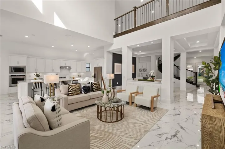 Living room with stairs, a high ceiling, and marble finish floor