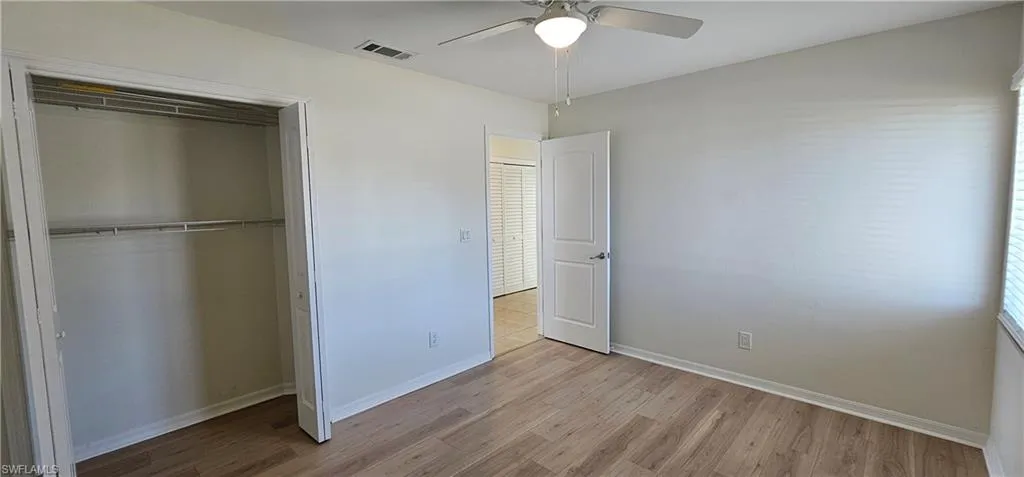Unfurnished bedroom with light wood-type flooring, a ceiling fan, and a closet