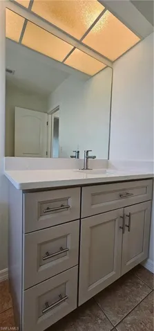 Bathroom with vanity and dark tile patterned floors