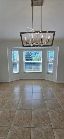 Unfurnished dining area with tile patterned flooring and hanging lights