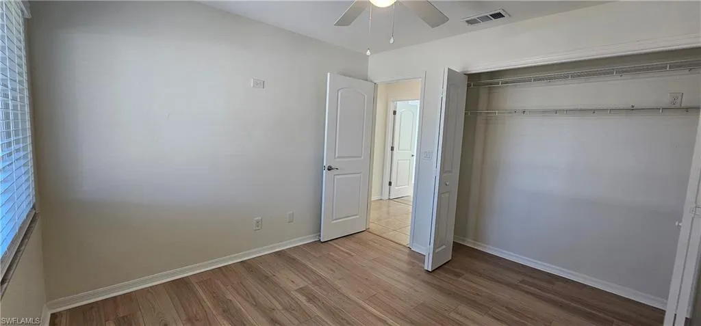 Unfurnished bedroom featuring light wood-style flooring, ceiling fan, and a closet