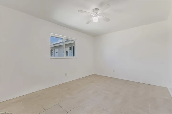 Empty room featuring ceiling fan and baseboards